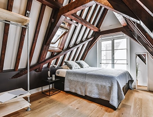 Dachgeschoss-Schlafzimmer-mit-weichem-Bett